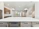 Modern kitchen with stainless steel wine cooler, pendant lighting, white countertop, and gray cabinets at 7404 Newham Ln, Sarasota, FL 34240