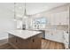 Bright kitchen featuring stainless steel appliances, white cabinets, and a large island with pendant lights at 7404 Newham Ln, Sarasota, FL 34240