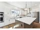 Bright kitchen featuring stainless steel appliances, white cabinets, and a large island with pendant lights at 7404 Newham Ln, Sarasota, FL 34240
