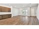 Open-concept living room with hardwood floors, brown cabinets, recessed lighting, and a sliding door to a balcony at 7404 Newham Ln, Sarasota, FL 34240
