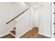 Bright entryway with hardwood floors and a staircase with a black metal railing at 7404 Newham Ln, Sarasota, FL 34240