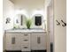 Double vanity bathroom with granite countertops and large round mirrors at 14028 Notreville Way, Tampa, FL 33624