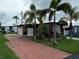 Red mobile home with palm trees and a fenced patio at 27466 Us Highway 19 N # 9, Clearwater, FL 33761