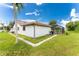 White house exterior with brown roof, pool, and lush green lawn at 684 Corrientes Cir, Punta Gorda, FL 33983