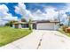 Single-story home with solar panels, attached garage, and a stone accent wall at 684 Corrientes Cir, Punta Gorda, FL 33983