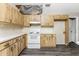 View of kitchen with wood cabinets, white appliances, and vinyl flooring at 684 Corrientes Cir, Punta Gorda, FL 33983