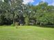 Large backyard with golf cart and mature trees at 15222 Lost Lake Ln, Lithia, FL 33547