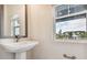 Modern bathroom with pedestal sink and a window offering a community view at 7412 Newham Ln, Sarasota, FL 34240