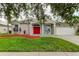 One-story home with red door and well-manicured lawn at 25954 Risen Star Dr, Wesley Chapel, FL 33544