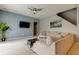 Spacious living room featuring a sectional sofa and wall-mounted TV at 25954 Risen Star Dr, Wesley Chapel, FL 33544