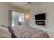 Main bedroom with large TV, fireplace and pool view at 25954 Risen Star Dr, Wesley Chapel, FL 33544