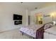 Main bedroom with mounted TV, fireplace, and bathroom access at 25954 Risen Star Dr, Wesley Chapel, FL 33544