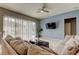 Bright living room with pool view, comfy seating, and large TV at 25954 Risen Star Dr, Wesley Chapel, FL 33544
