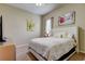 Comfortable bedroom with a queen-size bed, dresser, and artwork at 25954 Risen Star Dr, Wesley Chapel, FL 33544