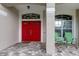 Inviting entryway with a red double door and a covered porch at 25954 Risen Star Dr, Wesley Chapel, FL 33544