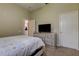 Serene bedroom with a queen bed, dresser, and access to hallway at 25954 Risen Star Dr, Wesley Chapel, FL 33544