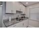 Modern kitchen with white cabinets, granite countertops, and updated appliances at 2438 Enterprise Rd # 6, Clearwater, FL 33763