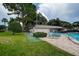 Community pool and shuffleboard area with lush green landscaping at 2438 Enterprise Rd # 6, Clearwater, FL 33763
