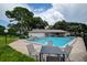 Community pool with lounge chairs and a patio table, perfect for relaxation at 2438 Enterprise Rd # 6, Clearwater, FL 33763