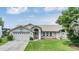 Exterior view of a single-story house with a two-car garage and a well-maintained lawn at 13199 Drysdale St, Spring Hill, FL 34609