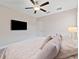 Relaxing bedroom with a plush bed, ceiling fan, and a wall-mounted TV at 9848 Wild Begonia Loop, Land O Lakes, FL 34637