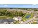 Aerial view of two-story house, community, and pond at 9848 Wild Begonia Loop, Land O Lakes, FL 34637