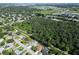 Aerial view of a residential area with a large wooded area adjacent to houses and roads at 3422 29Th E St, Bradenton, FL 34208
