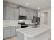 Modern kitchen with gray cabinets, quartz countertops and stainless steel appliances at 6161 Timberdale Ave, Wesley Chapel, FL 33545