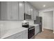 Modern kitchen with gray cabinets, stainless steel appliances, and quartz countertops at 6161 Timberdale Ave, Wesley Chapel, FL 33545
