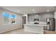 Modern kitchen with gray cabinets, quartz countertops, and stainless steel appliances at 6161 Timberdale Ave, Wesley Chapel, FL 33545