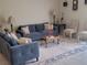 Living room featuring a blue sofa, area rug, and decorative pillows at 14443 Touch Gold Ln, Sun City Center, FL 33573