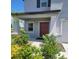 Front entrance with a brown door and landscaping at 14443 Touch Gold Ln, Sun City Center, FL 33573