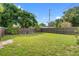 Fenced backyard with grass, trees, and lounge chairs at 5817 11Th S Ave, Gulfport, FL 33707