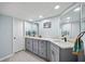 Modern bathroom with gray cabinets, marble countertops, and dual sinks at 3401 Cypress Head Ct, Tampa, FL 33618