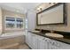 Elegant bathroom with double vanity and a soaking tub at 9506 Pebble Glen Ave, Tampa, FL 33647
