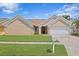 Tan house with a two-car garage, and nicely landscaped lawn at 9506 Pebble Glen Ave, Tampa, FL 33647