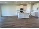 Open-concept kitchen featuring an island, stainless appliances, white cabinets, and wood-look floors at 16029 7Th E Ave, Bradenton, FL 34212