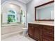 Bathroom with a soaking tub, walk in shower and dark wood vanity at 2501 N Dundee St, Tampa, FL 33629