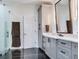 Bathroom with double vanity, large mirror and black marble floor at 2501 N Dundee St, Tampa, FL 33629