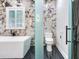 Bathroom with toilet, bathtub and marble tile at 2501 N Dundee St, Tampa, FL 33629