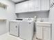 Bright laundry room, washer, dryer, cabinets, and utility sink at 2501 N Dundee St, Tampa, FL 33629