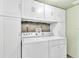 Laundry room with washer, dryer, and upper cabinets at 2511 Dolly Bay Dr # 301, Palm Harbor, FL 34684