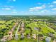 Wide aerial view of a residential community interwoven with a golf course and surrounding greenery and ponds at 13049 Thoroughbred Dr, Dade City, FL 33525