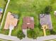 Aerial view of three homes with pools and well-kept lawns in a residential neighborhood at 13049 Thoroughbred Dr, Dade City, FL 33525