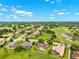 Extensive aerial view showcasing homes adjacent to a meticulously kept golf course and serene lake at 13049 Thoroughbred Dr, Dade City, FL 33525