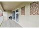 Open balcony featuring sliding glass doors, wood flooring, neutral stucco wall and chair seating at 13049 Thoroughbred Dr, Dade City, FL 33525