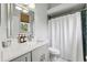 Well-lit bathroom with a white vanity, quartz countertop, and a shower with a white curtain at 13049 Thoroughbred Dr, Dade City, FL 33525