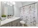 Bright bathroom featuring a white vanity, quartz countertop, and a shower with a Paris-themed curtain at 13049 Thoroughbred Dr, Dade City, FL 33525
