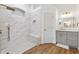 Beautiful bathroom with a glass enclosed shower featuring bench, white marble tiling with gold accents, and wood look ceramic tile floors at 13049 Thoroughbred Dr, Dade City, FL 33525