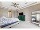 Spacious bedroom with a tray ceiling, green dresser, and a large mirror reflecting a bed at 13049 Thoroughbred Dr, Dade City, FL 33525